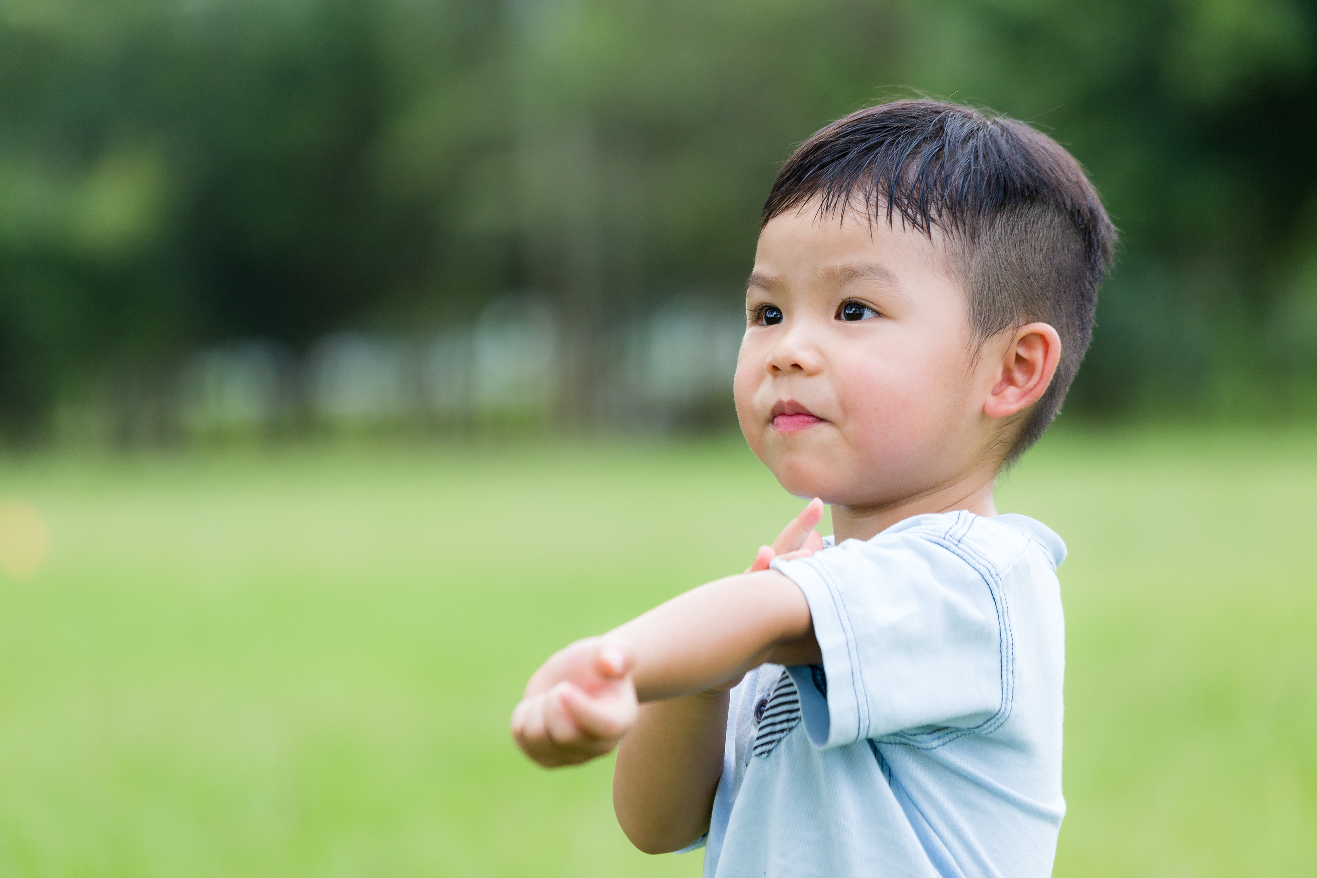 Asian boy scratching his arm