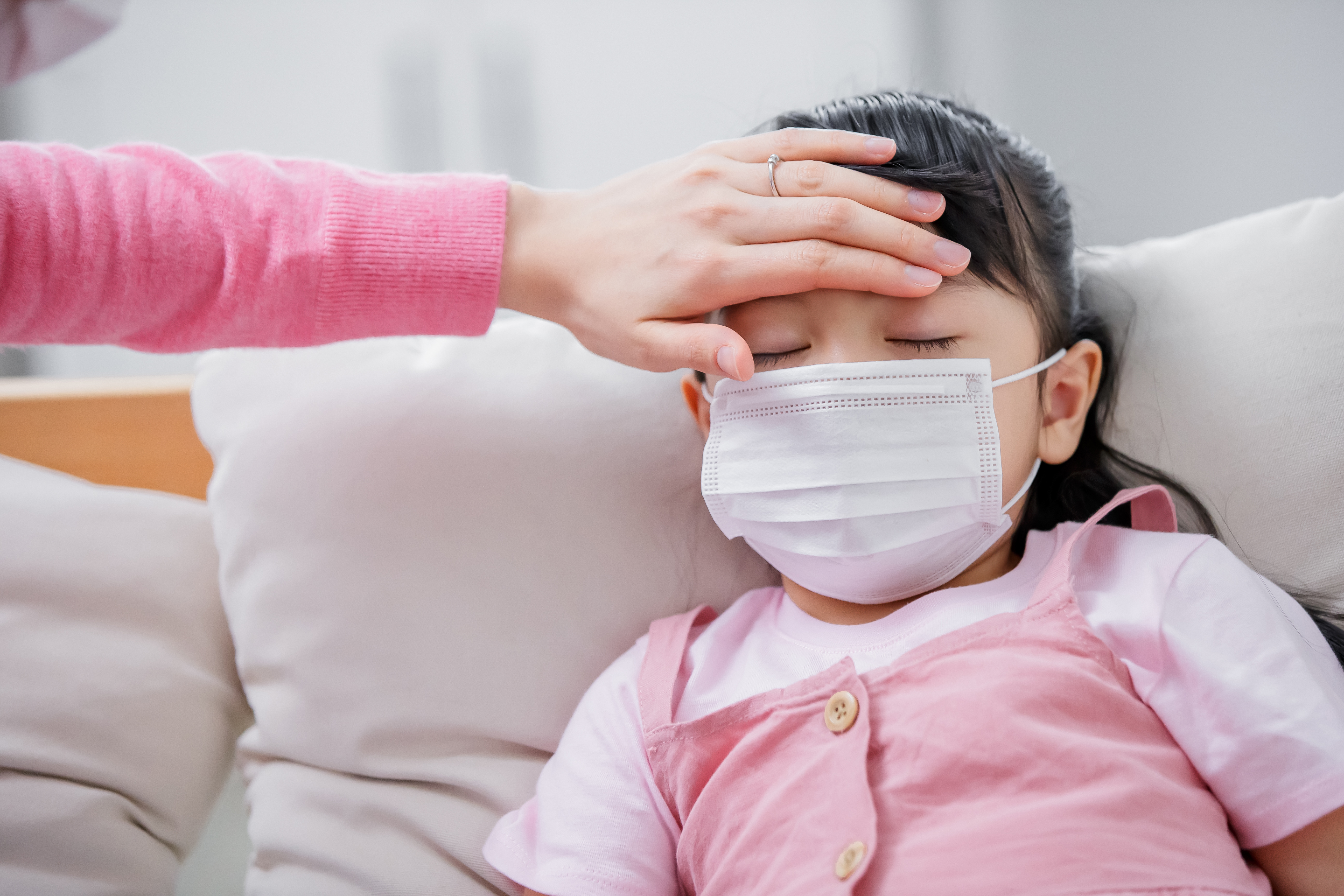 Mom touch kids forehead to check her fever condition at home